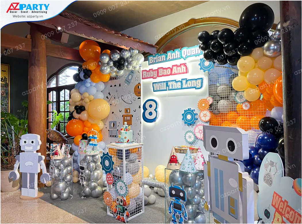 Góc chụp nghiêng bàn gallery trang trí sinh nhật chủ đề robot có các đôn trụ acrylic chứa bong bóng và standee robot sinh động bằng giấy cứng.