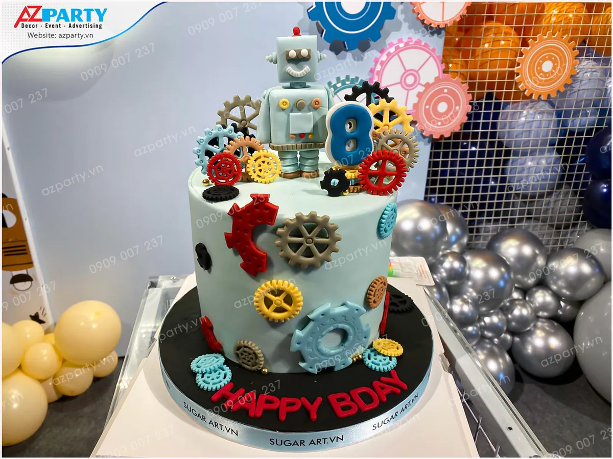 Cận cảnh chiếc bánh kem sinh nhật màu xanh mint dễ thương được tạo hình chú robot nhỏ và đắp các bánh răng fondant tỉ mỉ xung quanh.