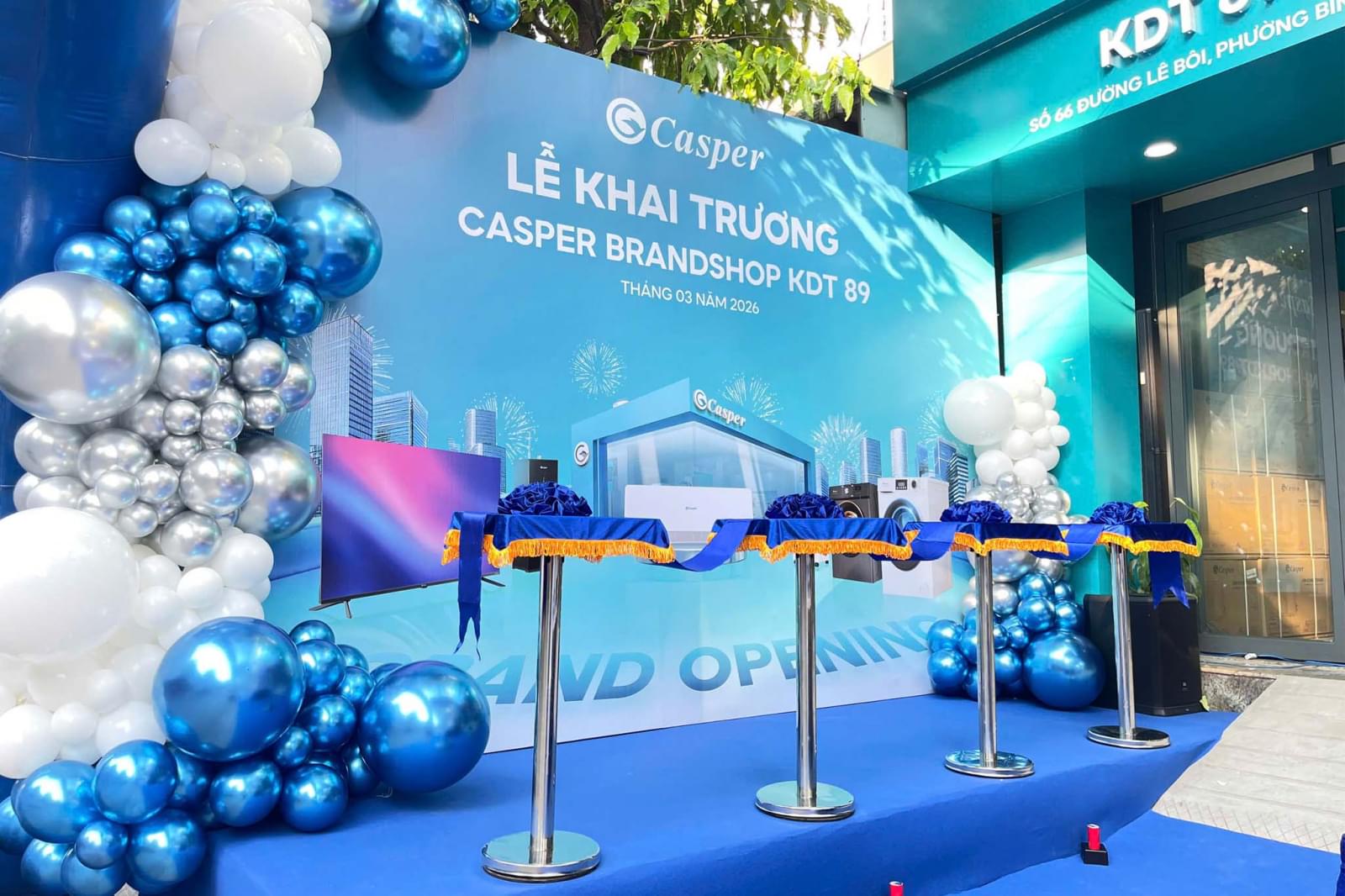 Backdrop lễ khai trương Casper Brandshop KDT 89 với tone xanh, trang trí bóng bay, khu vực cắt băng khánh thành sang trọng ngoài trời