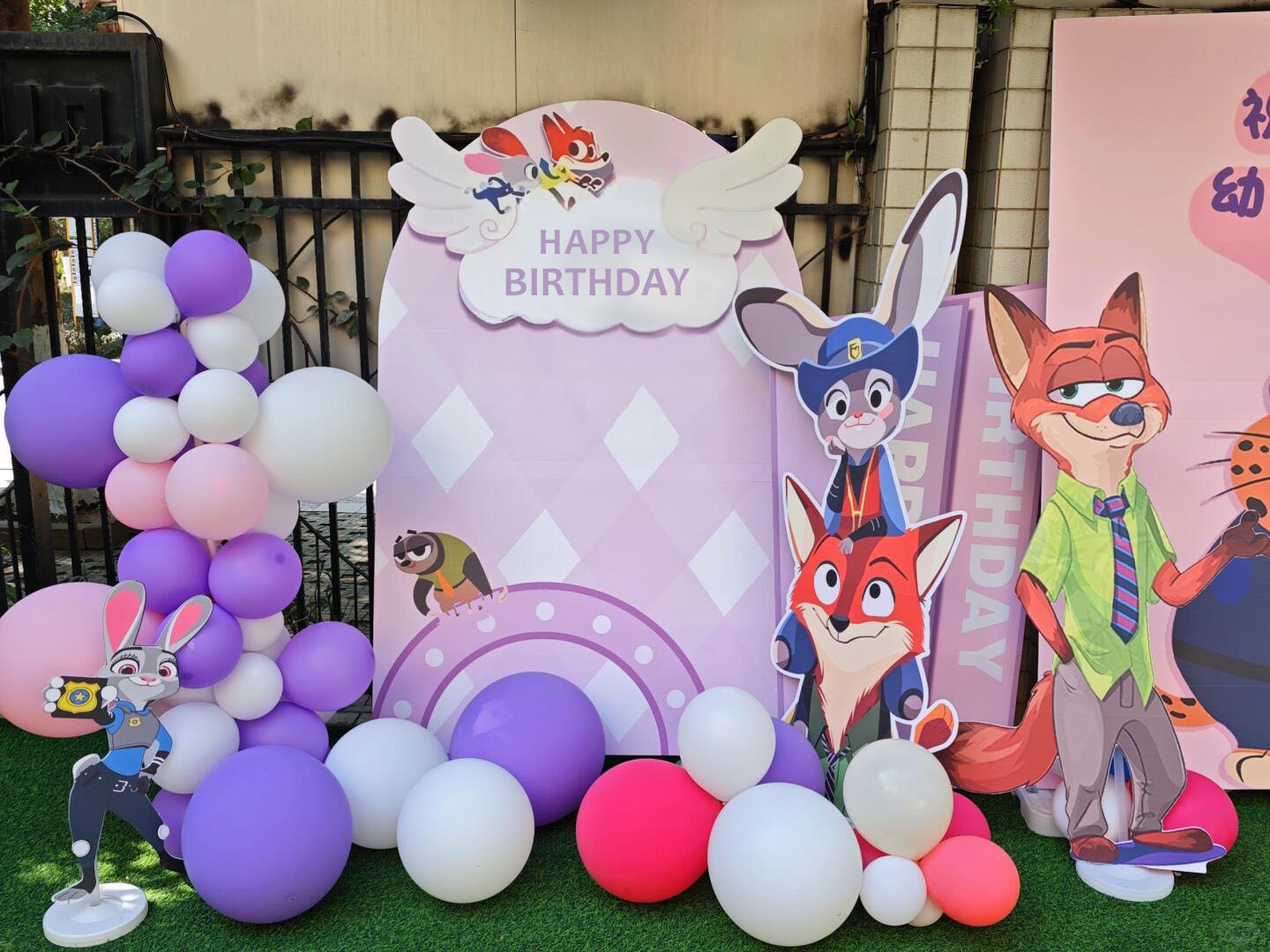 Backdrop sinh nhật Zootopia tông tím hồng với nhân vật Nick Wilde và Judy Hopps, bảng Happy Birthday và trang trí bóng bay