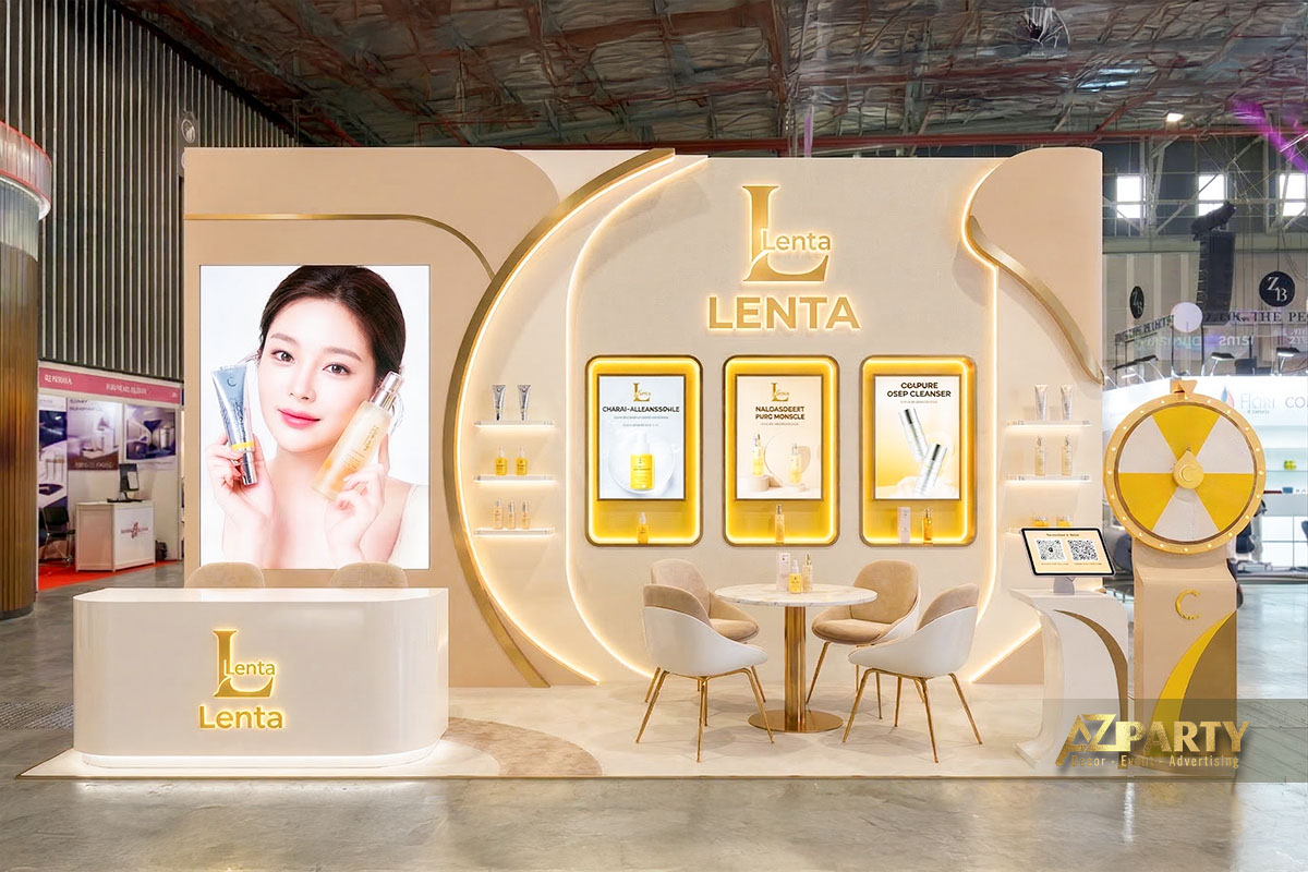 Gian hàng triển lãm mỹ phẩm tone trắng vàng sang trọng với kệ trưng bày sản phẩm, màn hình Led 3D chiếu sản phẩm, bảng minigame 