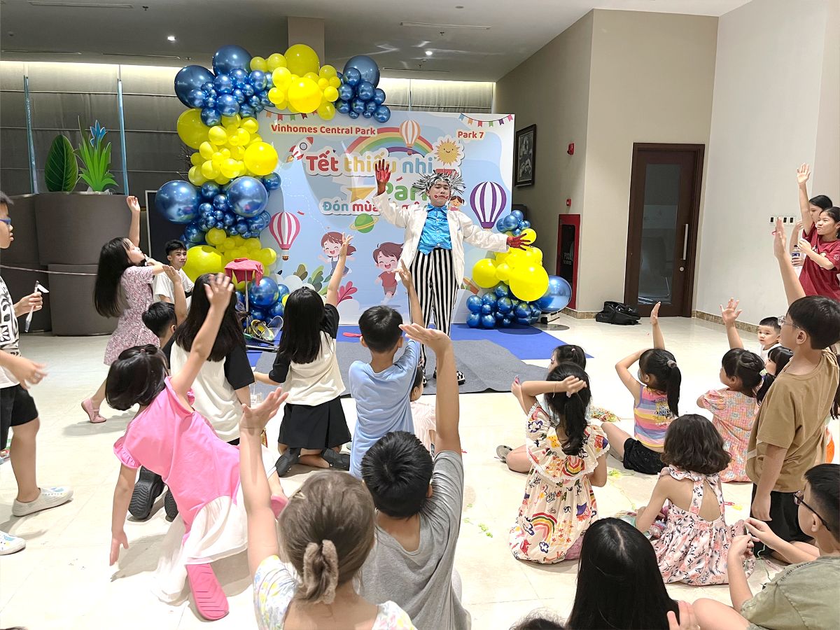 Các em nhỏ vui vẻ xem tiết mục biểu diễn của chú hề