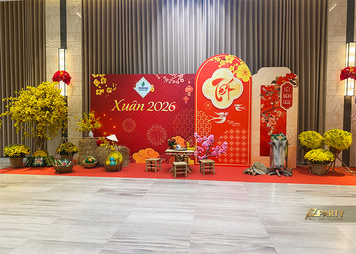 Booth checkin Tết với phông nền màu đỏ nổi bật với cây mai, các chi tiết pháo hoa, hoa, cánh én, quầy bánh trưng truyền thống 