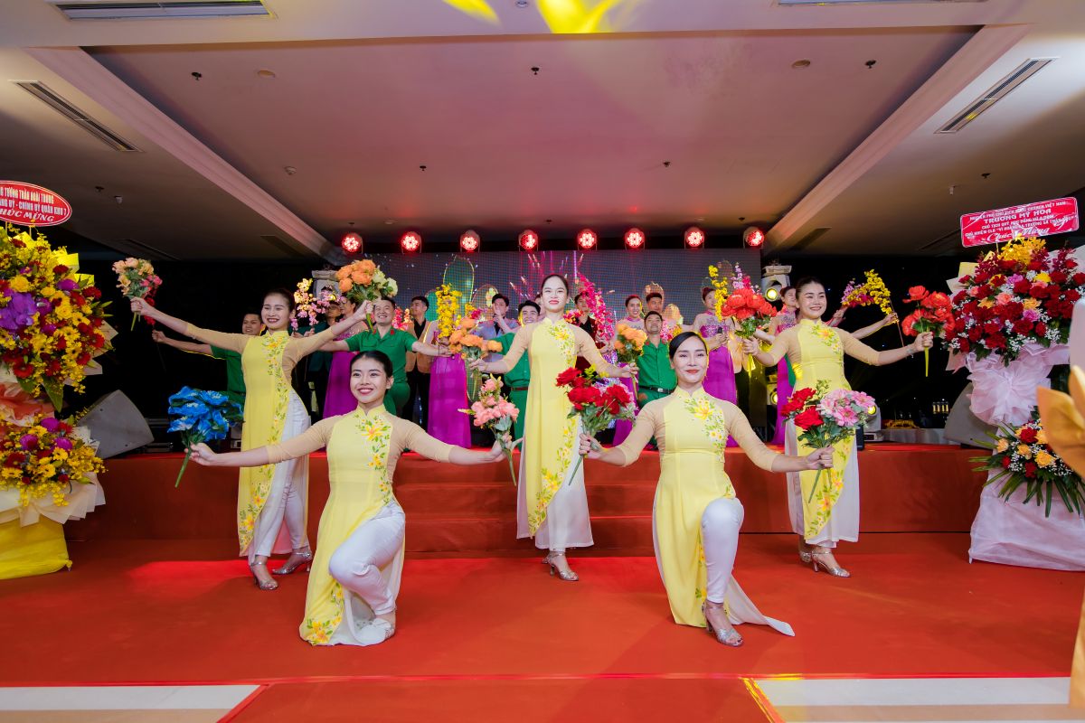 các dancer nữ với trang phục áo dài, cầm bông cho tiết mục hát 