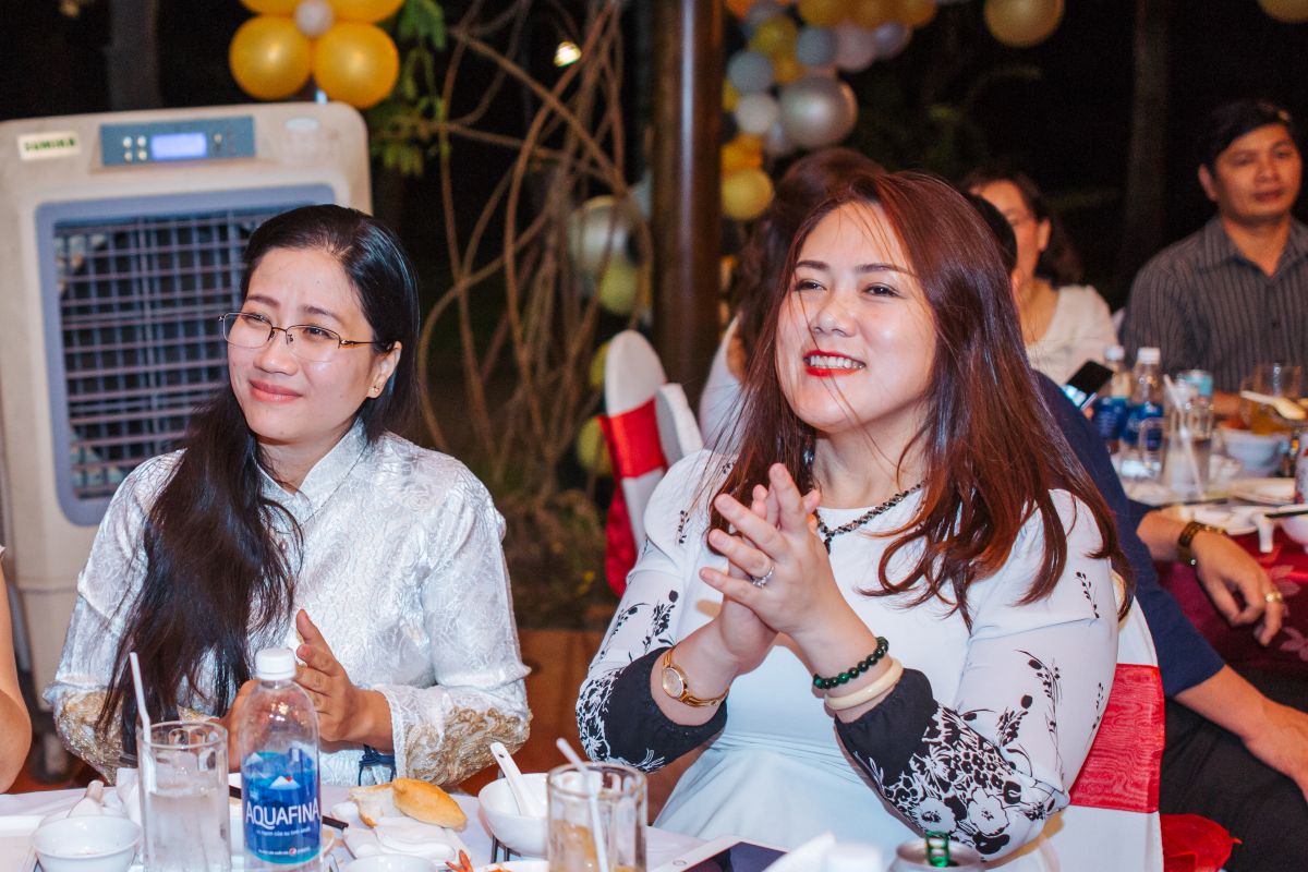 Khách mời tươi cười thưởng thức chương trình tại bàn tiệc