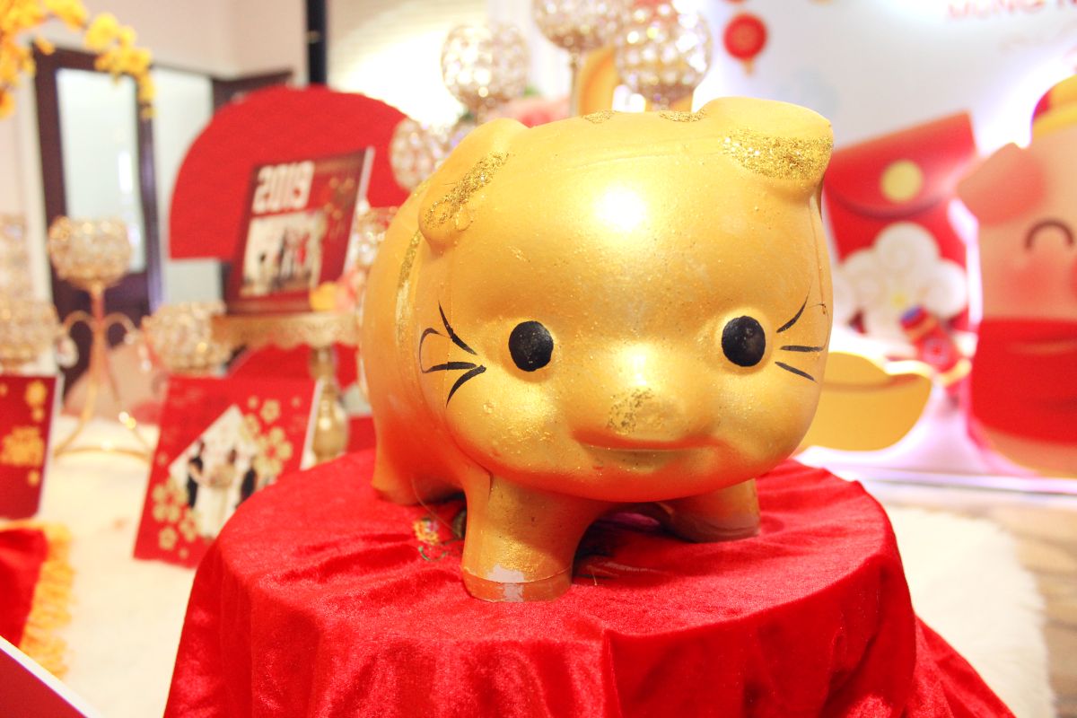 Chú heo đất màu vàng gold được đặt trên bàn gallery