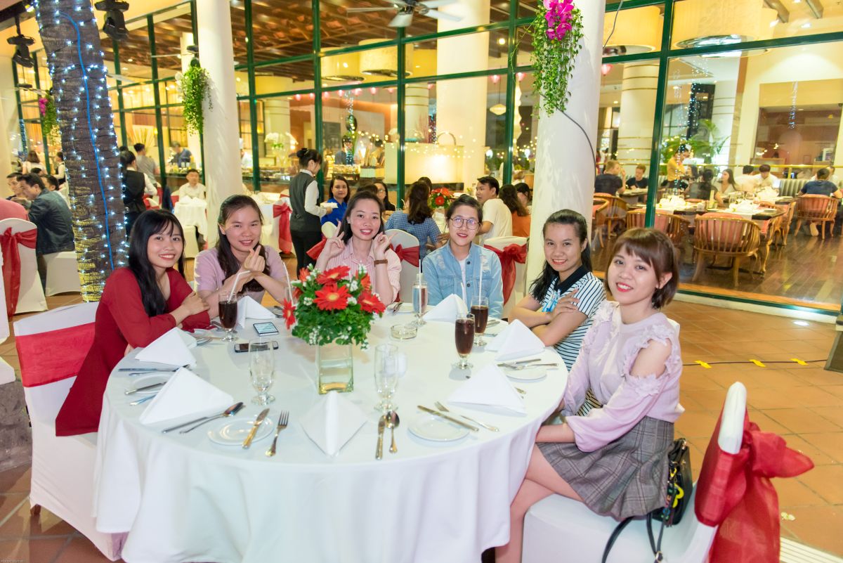 nhóm nhân viên nữ chụp hình tại bàn tiệc