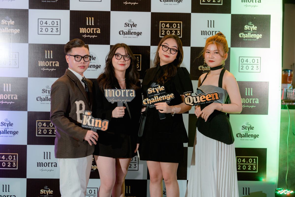 nhóm 3 nhân viên nữ và 1 nhân viên nam chụp kình kỷ niệm, trên tay cầm các hashtag