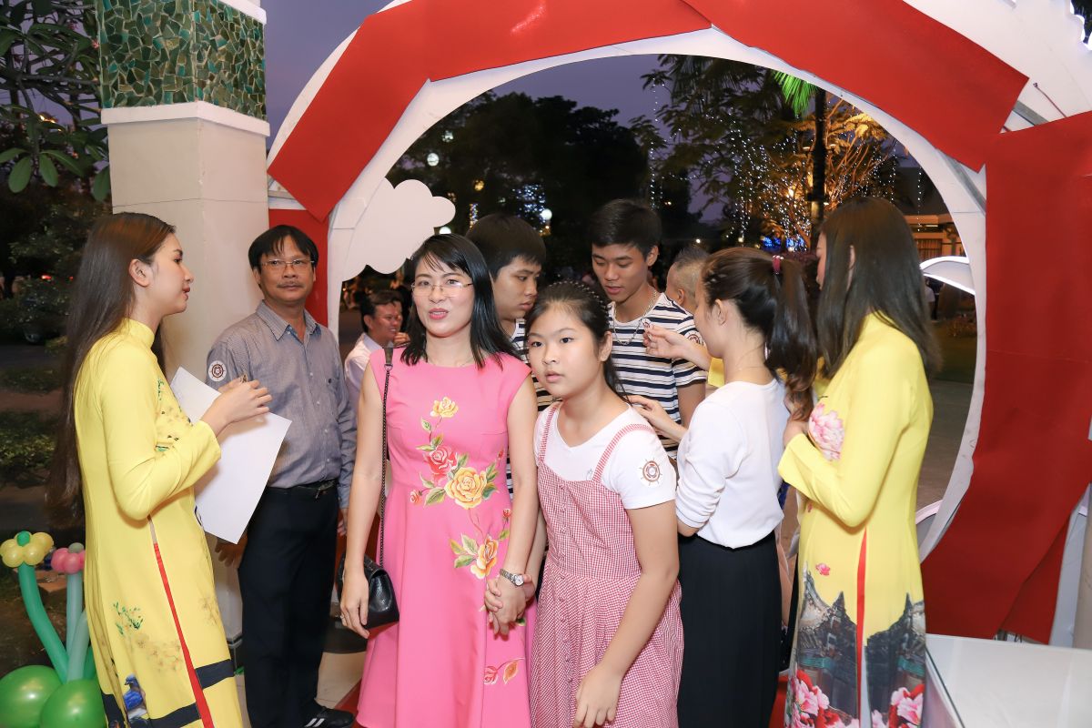 nhân viên bước vào buổi tiệc, 2 bên cổng có 2 PG đứng chào khách