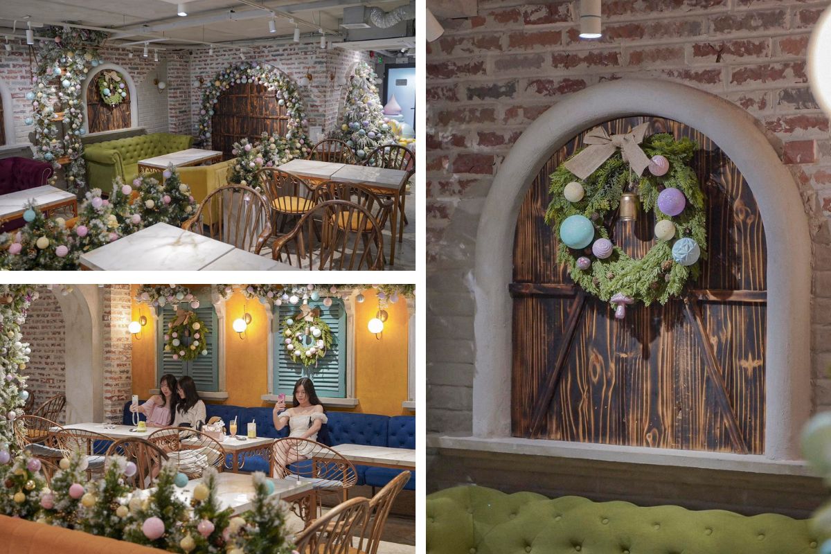 Khu vực ngồi trong quán cà phê được trang trí với vòng nguyệt quế Giáng sinh, cây thông nhỏ và dải hoa pastel. Không gian tường gạch, ghế nhung và ánh đèn vàng tạo cảm giác ấm cúng, dễ chịu cho khách khi thưởng thức cà phê mùa lễ hội.