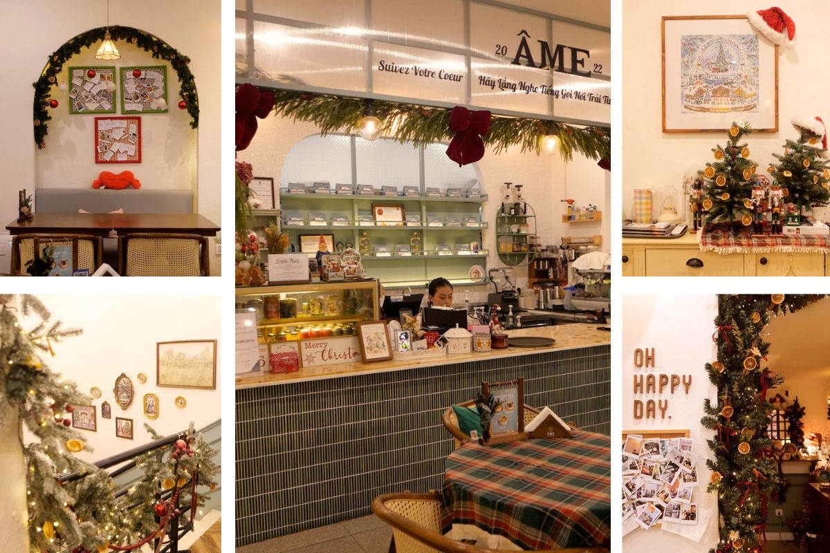 Quán cà phê trang trí Giáng sinh với tông vàng ấm, cây thông nhỏ, dây đèn và vòng lá thông điểm cam khô. Khu vực quầy bar và bàn khách được sắp xếp gọn gàng, mang phong cách cổ điển nhẹ nhàng, tạo không gian thư giãn và ấm cúng trong mùa lễ hội.