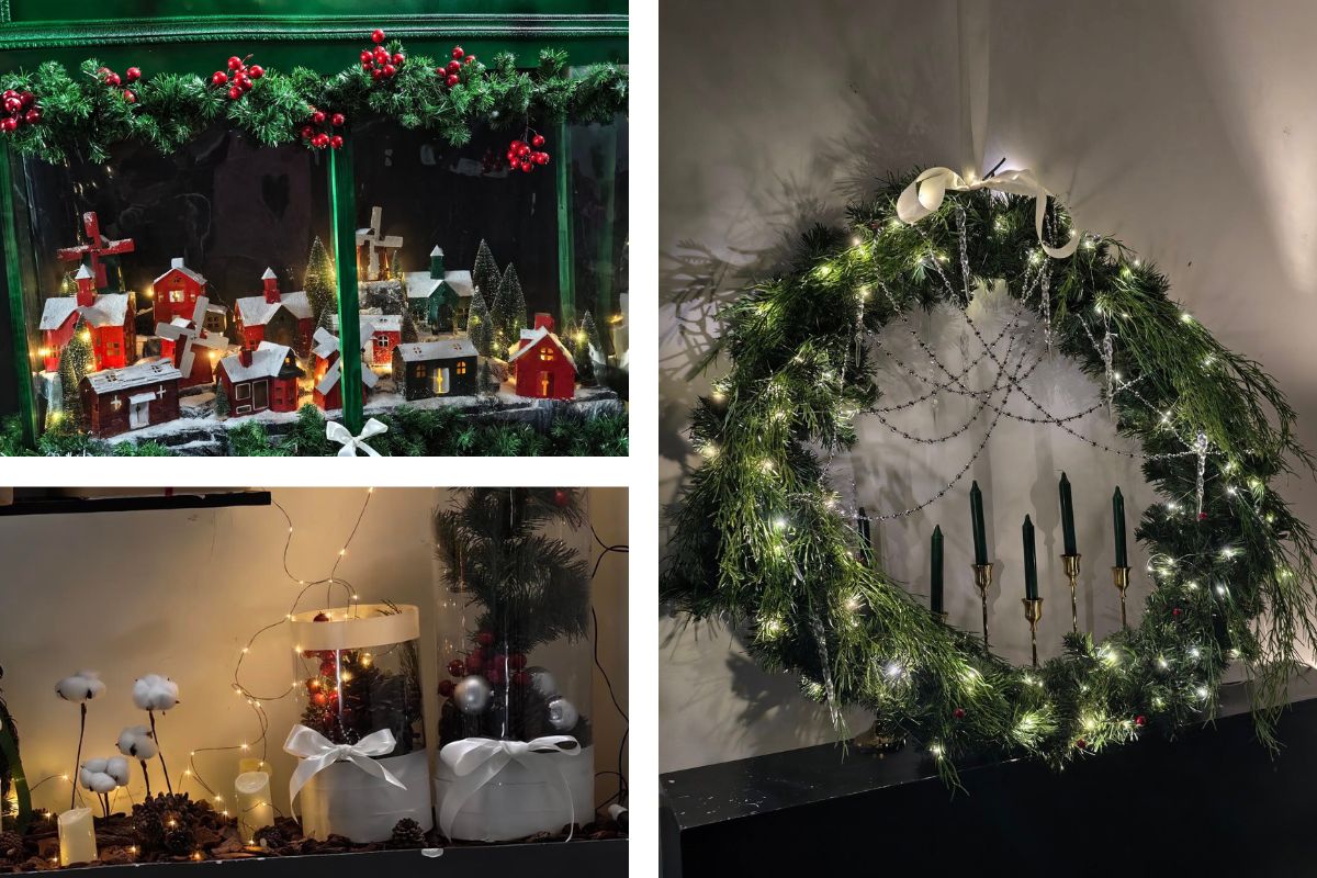 Không gian Giáng sinh với mô hình ngôi làng nhỏ phủ tuyết, vòng nguyệt quế lớn gắn đèn và nến xanh đậm. Các chi tiết như bông gòn, quả thông và dây đèn vàng mang lại cảm giác ấm áp, gần gũi và đậm chất mùa đông.