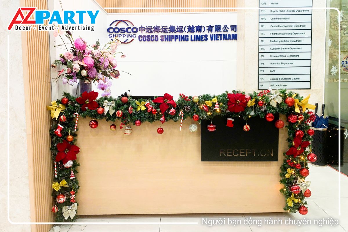 trang trí dây thông đính quả châu, nơ vàng và hoa trạng nguyên tại quầy lễ tân