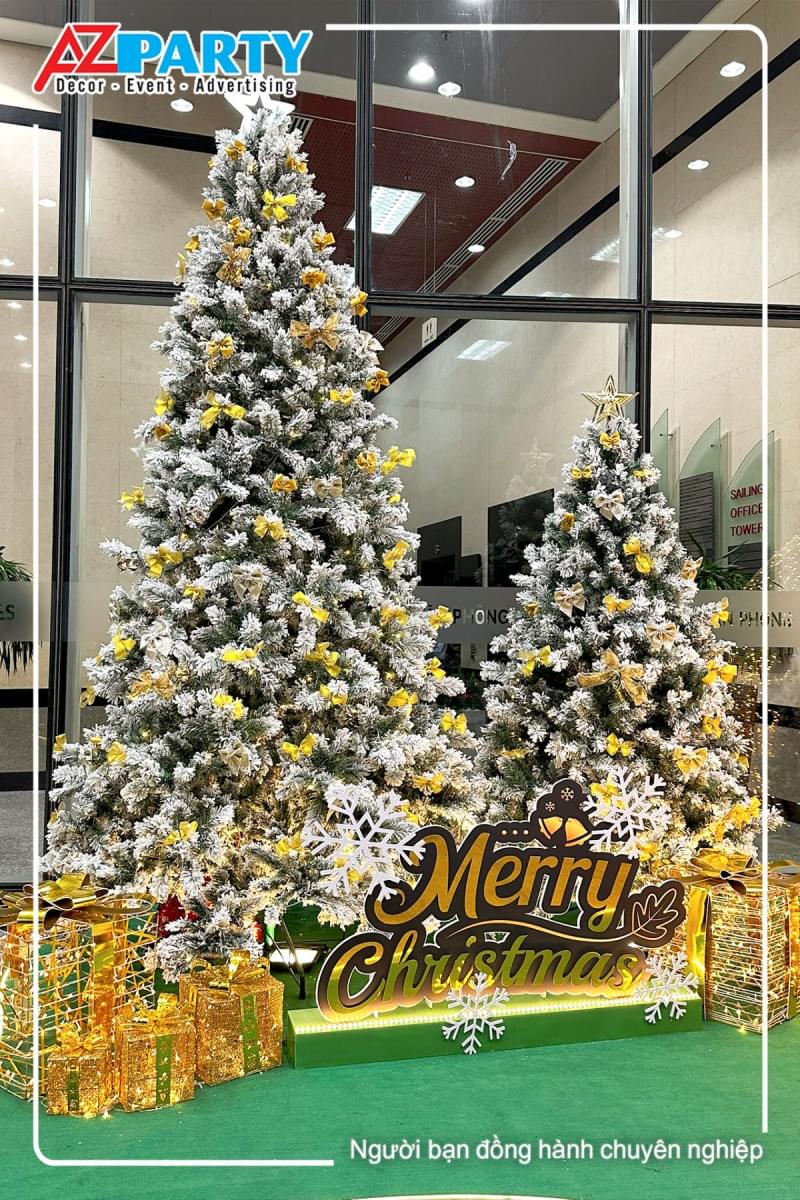 cây thông noel phủ tuyết trắng, trên ngọn có ngôi sao, thân cây có đính nơ vàng lấp lánh