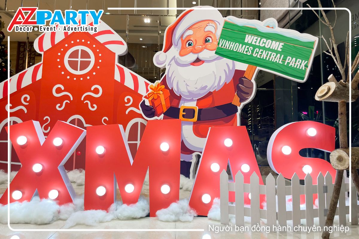 ông già noel cầm bằng welcome tại sảnh A và dòng chữ XMAS