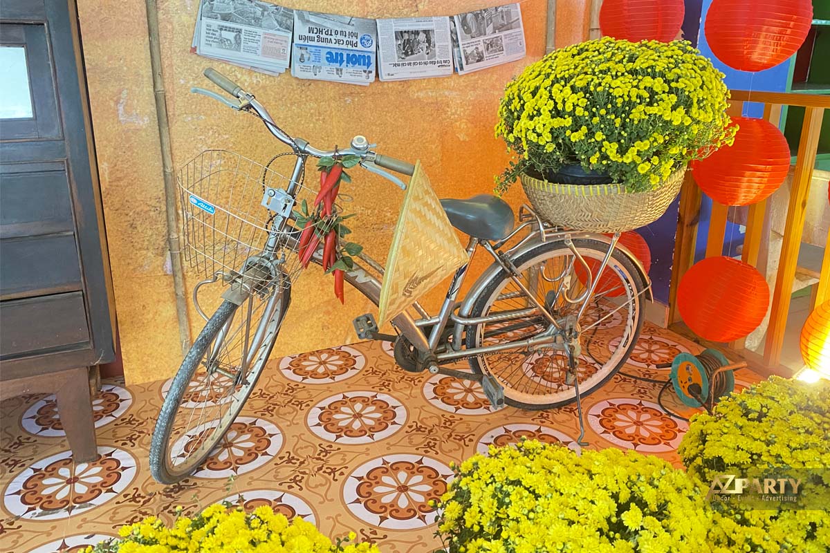 Một góc trang trí tết xưa với hoa thọ vàng và chiếc xe đạp cũ 