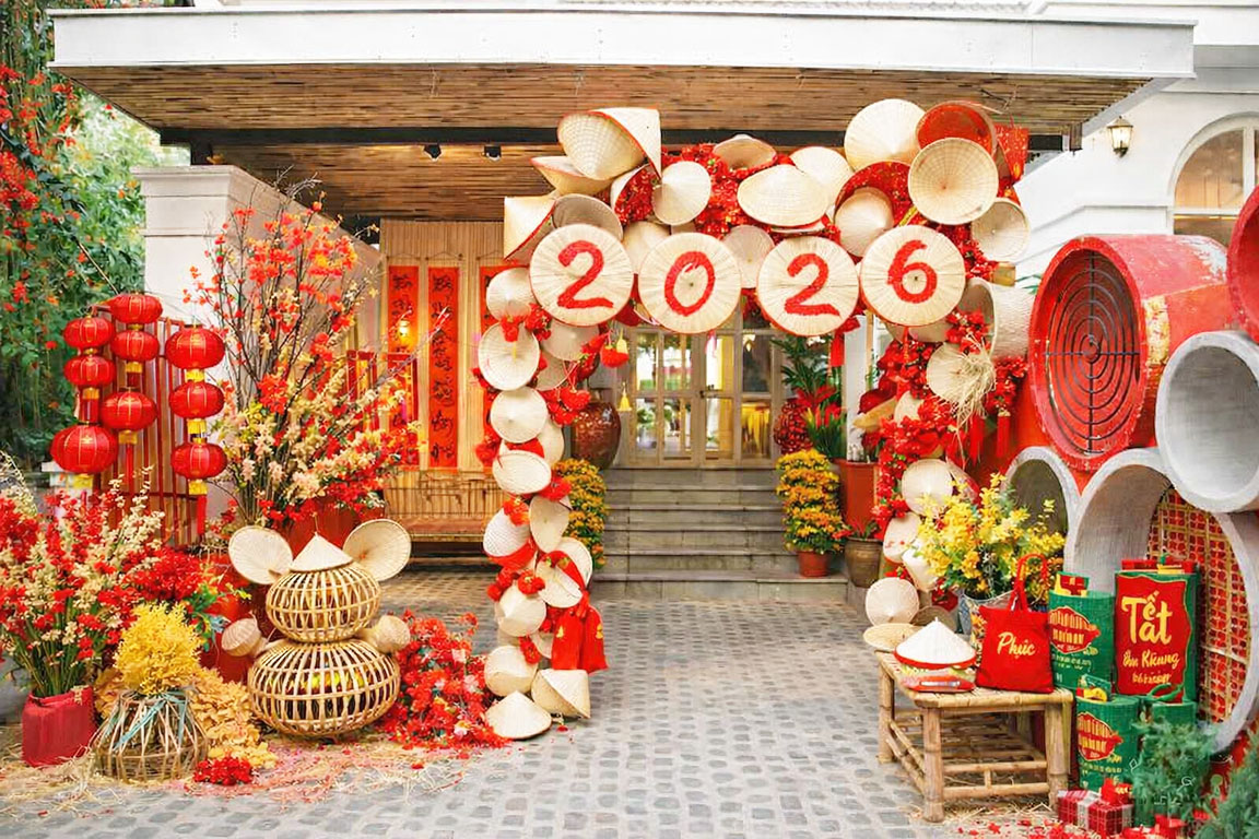 Tiểu cảnh Tết 2026 với cổng trang trí nón lá truyền thống, tone đỏ trắng nổi bật, không gian decor Tết Việt Nam rực rỡ 