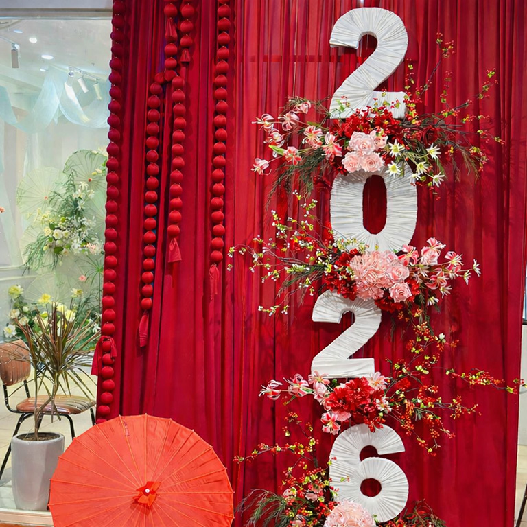 Mẫu trang trí Tết phối hoa rực rỡ với rèm đỏ, dây nhung thắt 