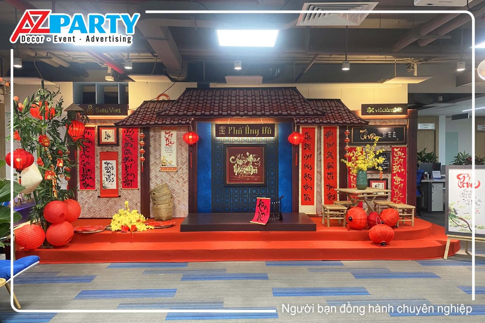 Tiểu cảnh Tết văn phòng phong cách Phố Ông Đồ, tái hiện không gian Tết xưa với thư pháp, đèn lồng đỏ, bàn ghế tre và mái ngói cổ.