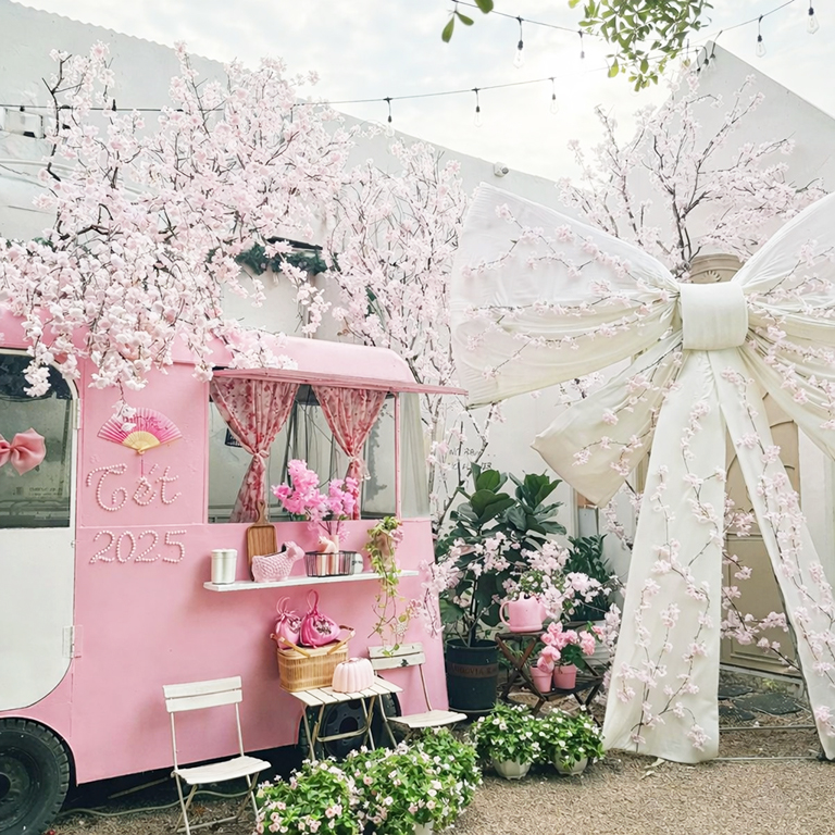 Decor tết quán cafe concept hồng nhẹ nhàng, với chiếc xe bus hồng giữa vườn hoa đào thơ mộng