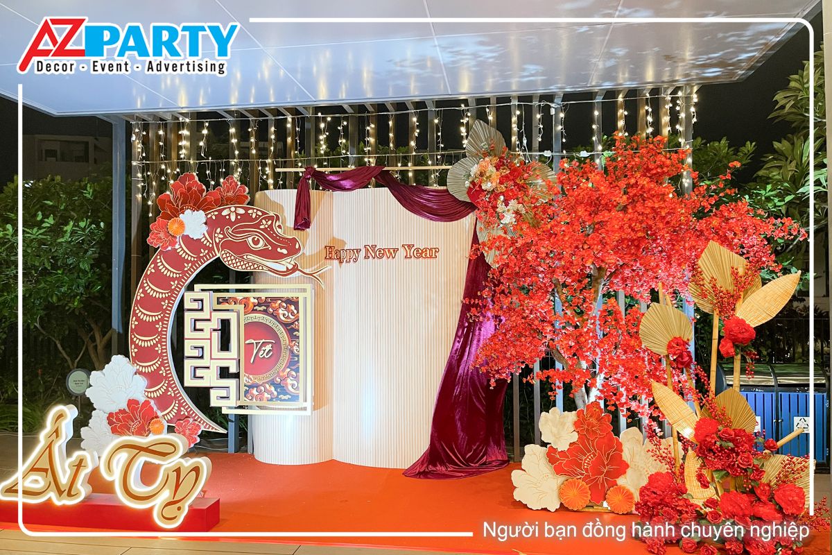 toàn cảnh tiểu cảnh tết Ất Tỵ tại chung cư One Verandah với tone mà đỏ đô. Bên phải của tiểu cảnh là cây đào đỏ rực, bên trái  là dòng chữ Ât Tỵ cùng chú rắn linh vật uốn cong, chính giữa là vách chính theo phong cách gấp khúc, có dòng chữ Happy New Year nổi bật