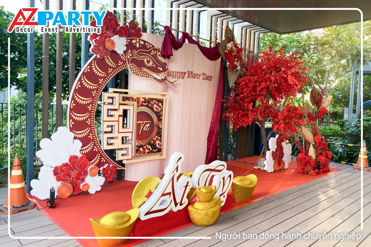 góc trái của tiểu cảnh nổi bật với dòng chữ Ất Tỵ, dưới chân có dặt các đồng tiền vàng và thỏi vàng