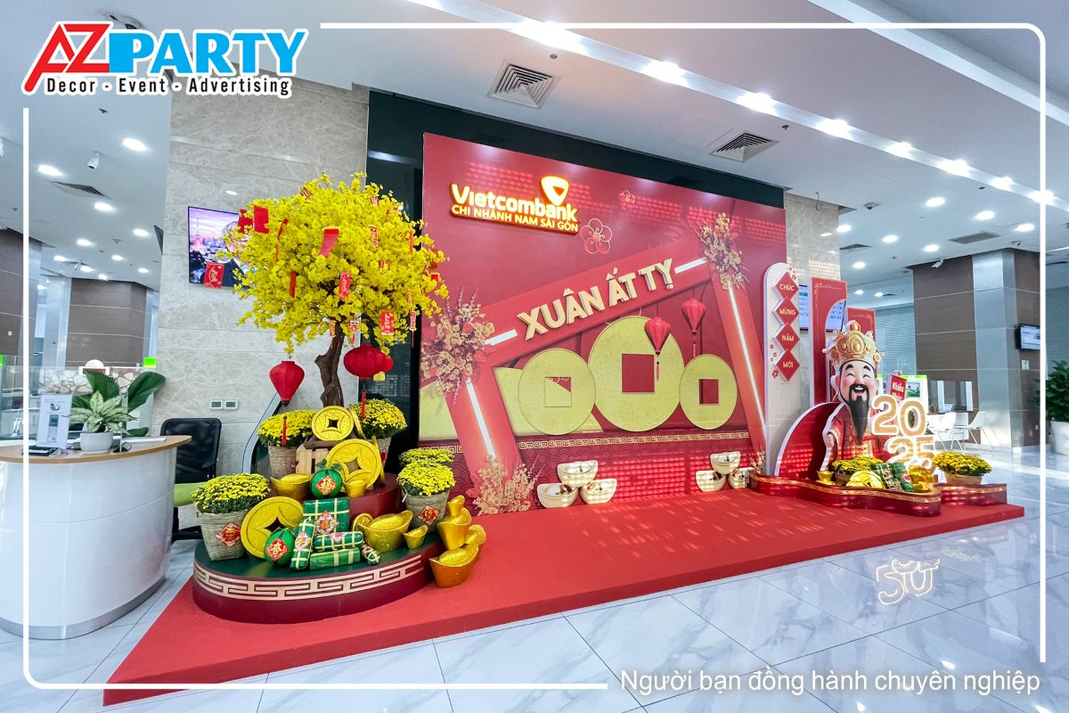 góc bên trái của tiểu cảnh, hình ảnh cây mai có treo liễn, lồng đèn, dưới gốc cây là các chậu cúc mâm xôi cùng những thỏi tiền vàng và bánh trưng bánh tét