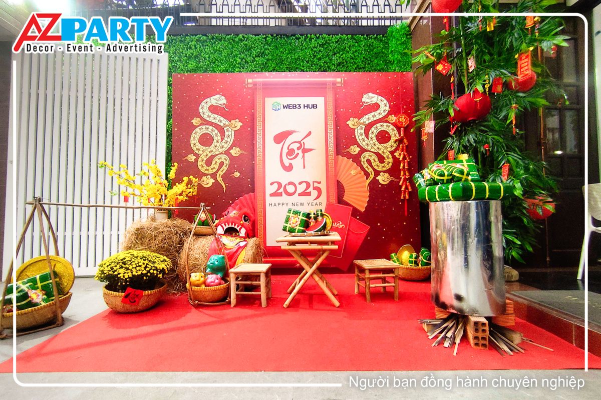 tiểu cảnh tết tại công ty Web 3 Hub, bên trái với đòn gánh bánh chưng bánh tét, bên phải là nồi bánh chưng xanh, chính giữa là bộ bàn ghế tre